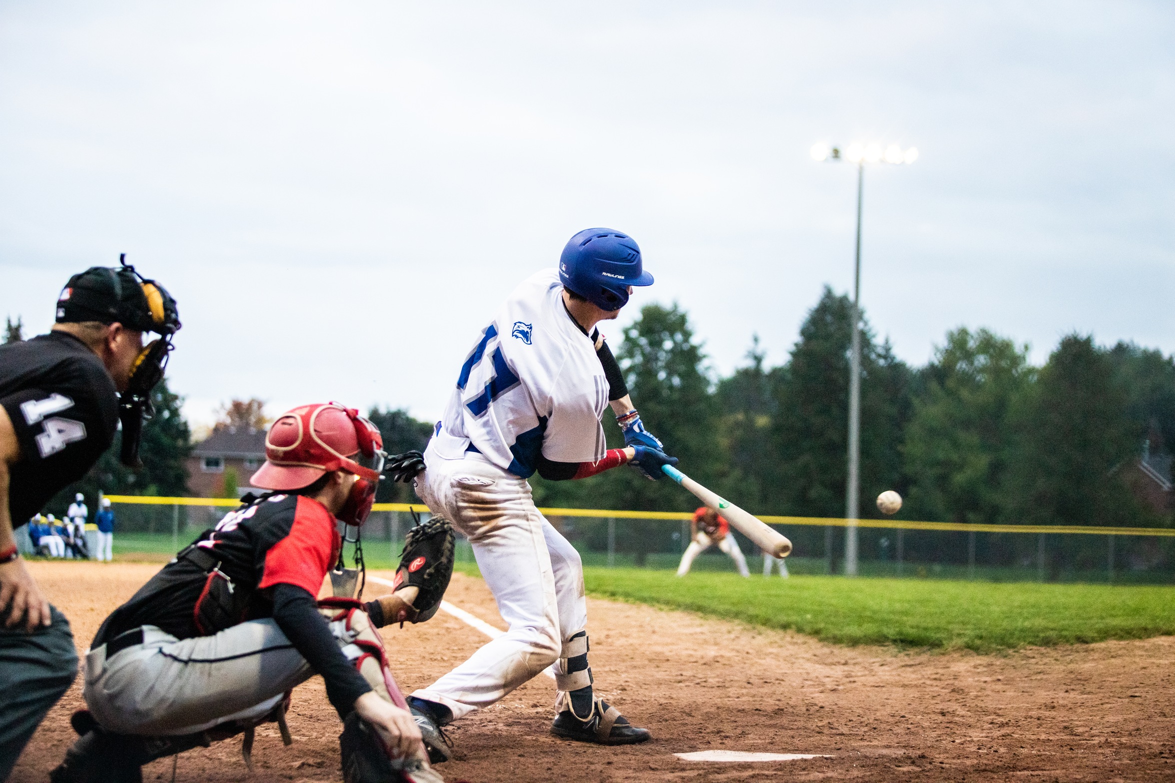 Huskies batter #17 swings at a pitch in front of Seneca catcher and umpire