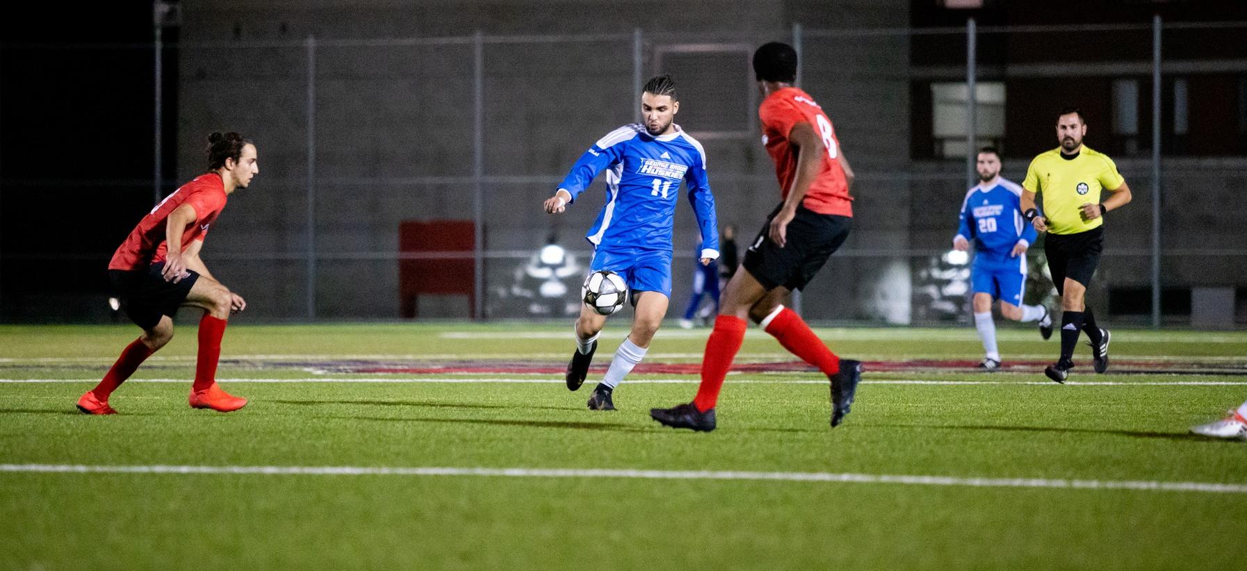 George Brown soccer player controls ball in front of Seneca player