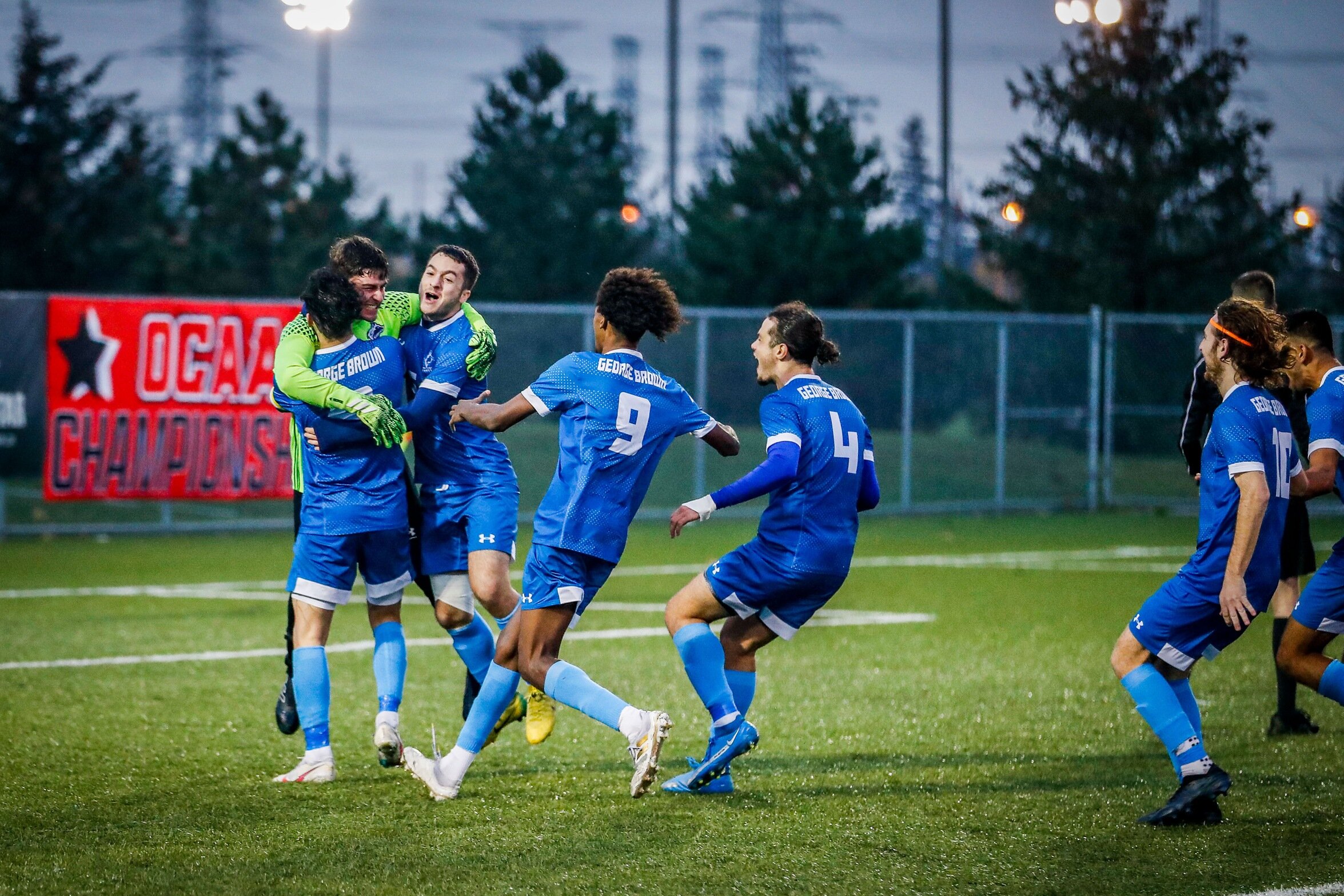 Huskies players hug goalie to celebrate win