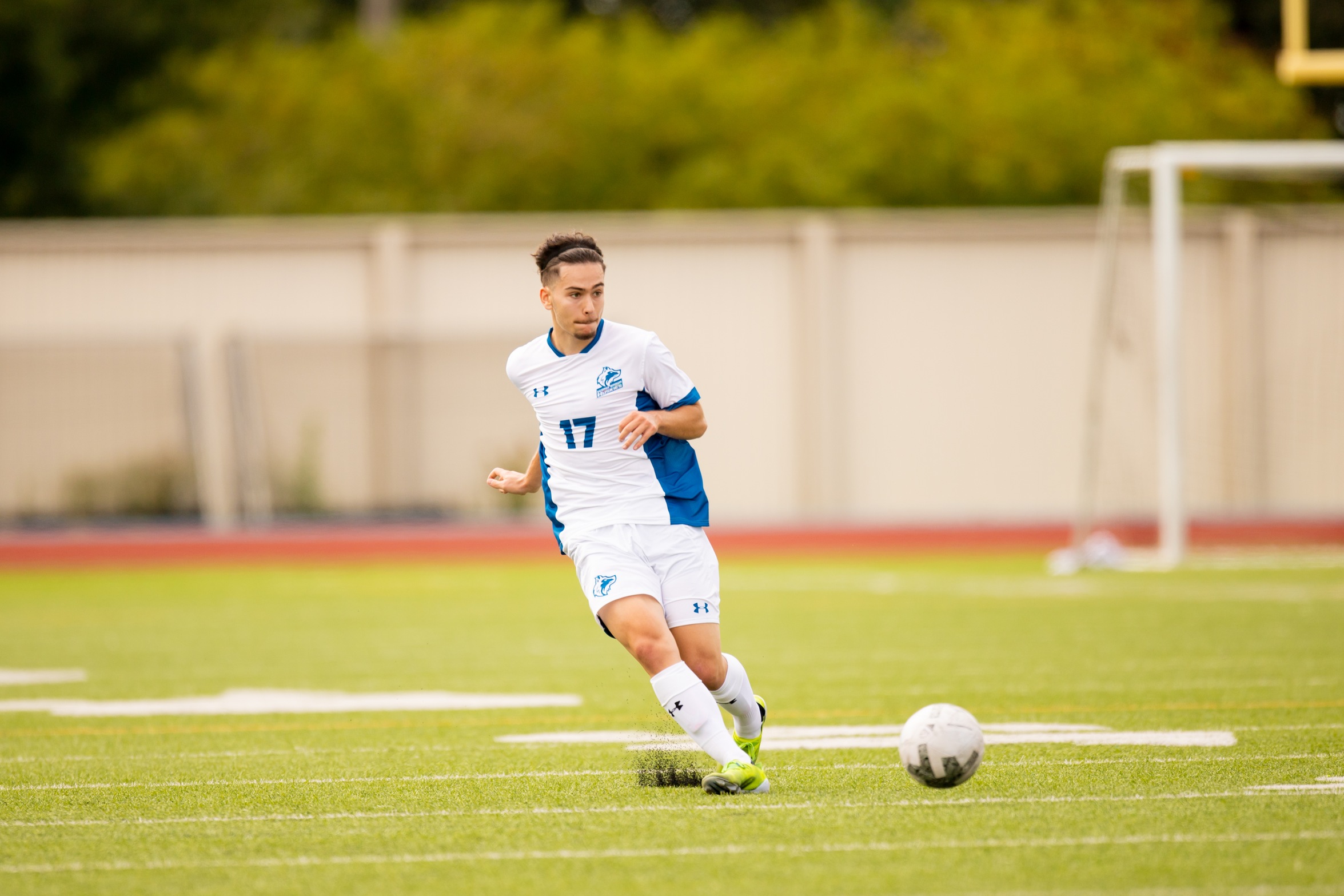 Huskies #17 mens' soccer player passes ball