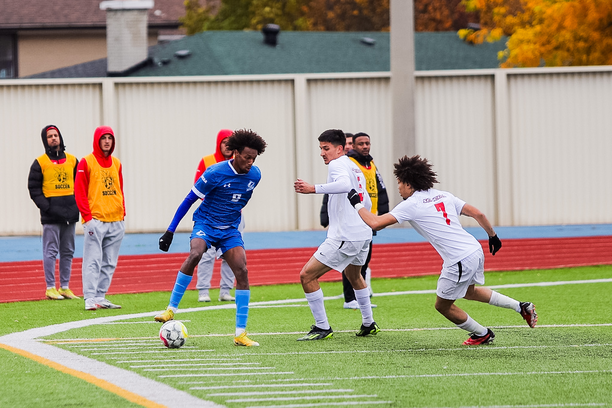 Huskies forward gets defended by two Seneca players. 