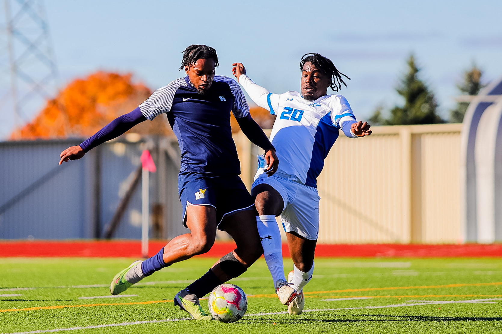 two soccer players fight for the ball