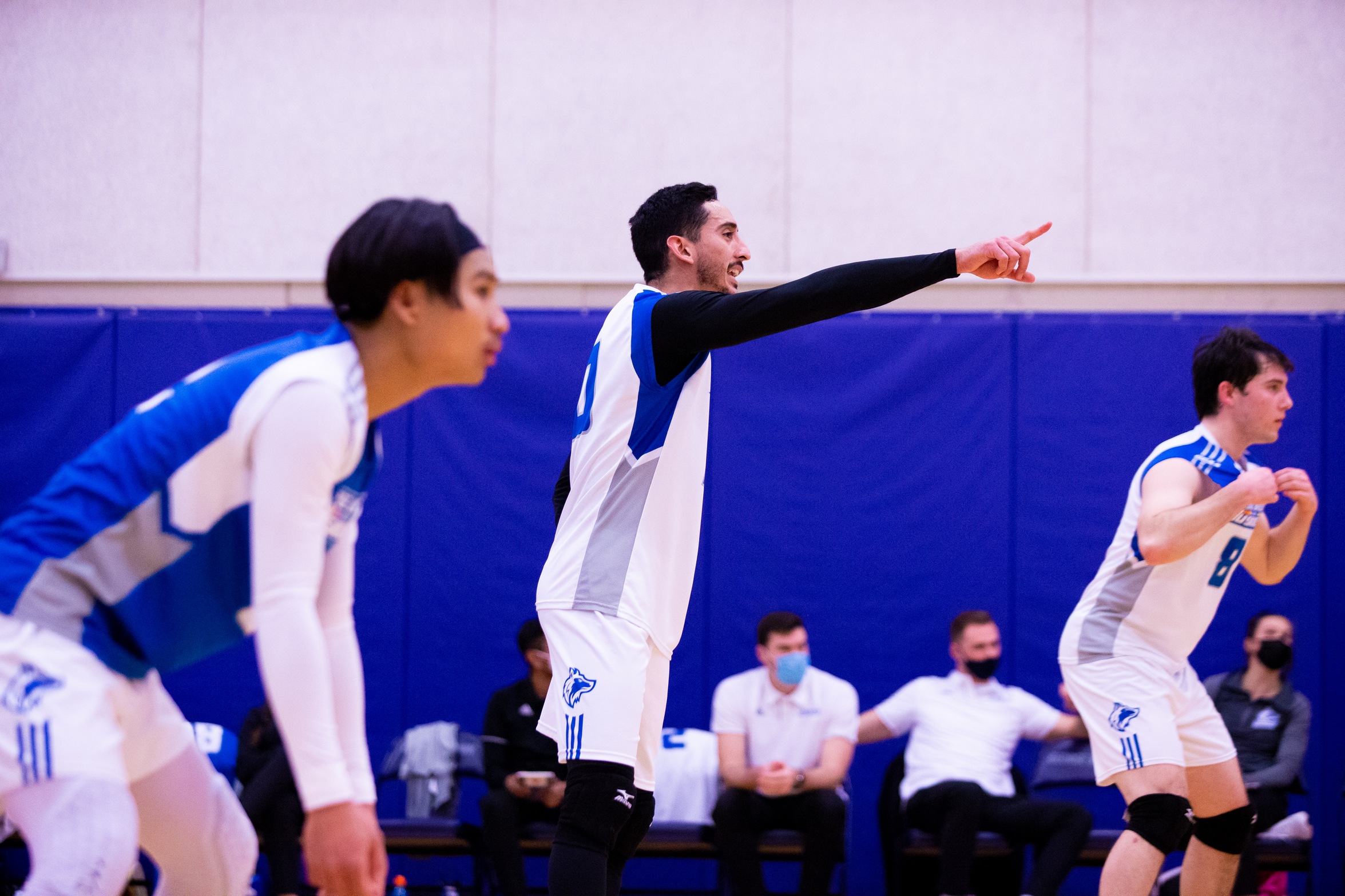 Huskies players lined up for serve, one player pointing