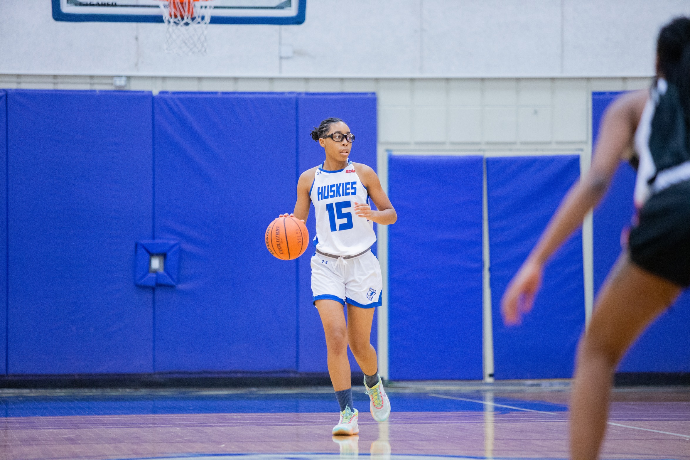 Huskies womens basketball player #15 dribbles up the court