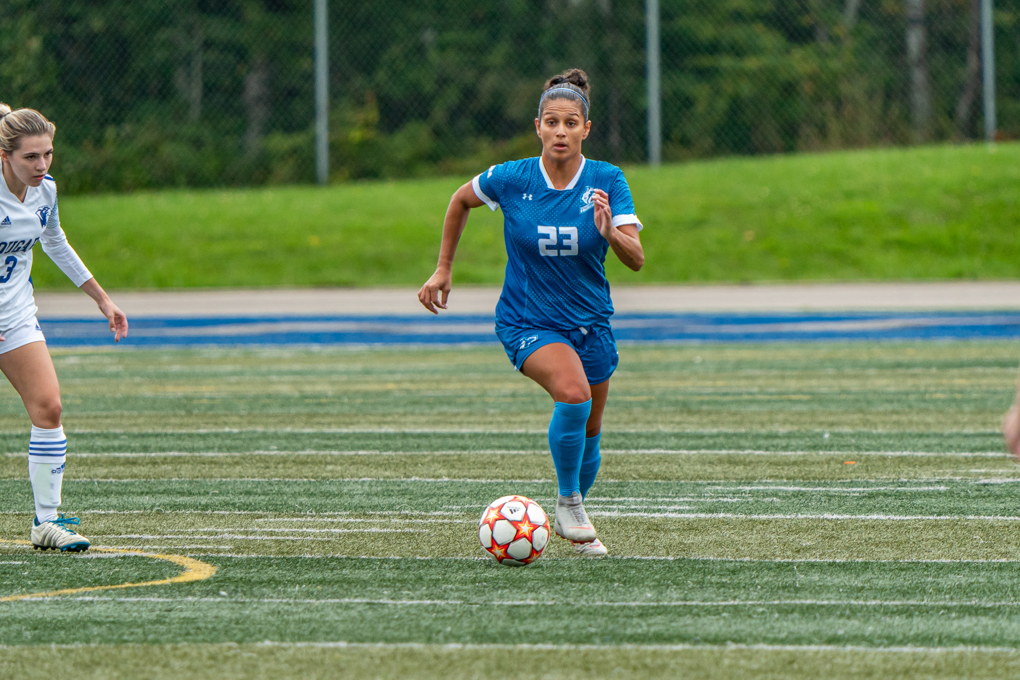 Huskies #23 Nikki Carvalho dribbles ball up field