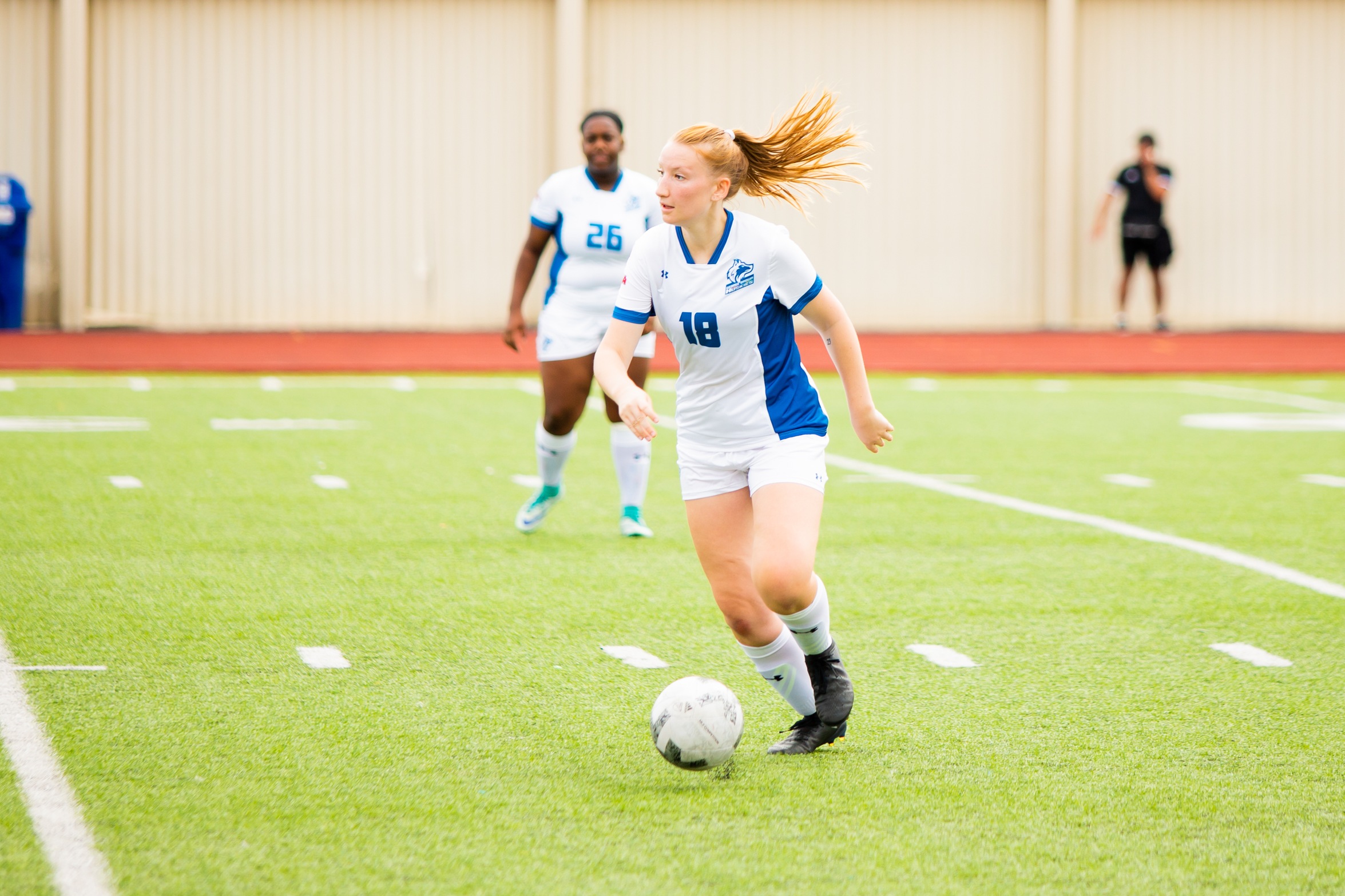 Huskies #18 looks upfield with soccer ball