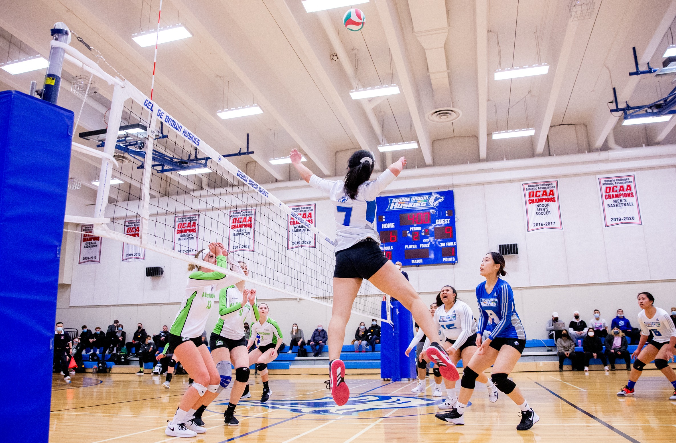 Volleyball player spikes ball 